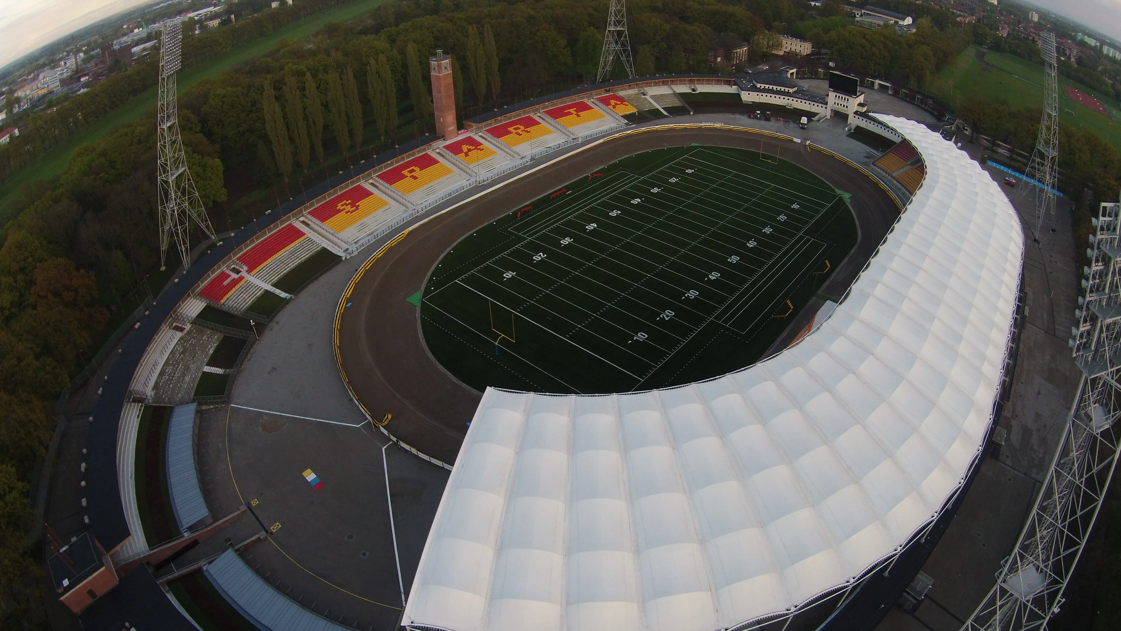 Stadion Olimpijski z lotu ptaka: tor żużlowy, boisko z oznaczeniami futbolowymi oraz zadaszona trybuna.